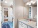 Bright bathroom featuring a single sink vanity, blue tile flooring, and a glimpse into an adjacent bedroom at 3990 Wesley Chapel Rd, Marietta, GA 30062