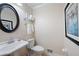 Powder room featuring a round mirror, pedestal sink, and elegant fixtures for a luxurious feel at 3990 Wesley Chapel Rd, Marietta, GA 30062