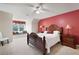 Cozy bedroom with a red accent wall, window nook, and a wooden queen bed at 3990 Wesley Chapel Rd, Marietta, GA 30062