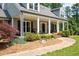 Inviting front porch with white columns and brick walkway, enhanced by mature landscaping at 3990 Wesley Chapel Rd, Marietta, GA 30062