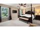 Spacious main bedroom with a four-poster bed, sitting area, and natural light from large windows at 3990 Wesley Chapel Rd, Marietta, GA 30062