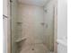 Modern walk-in shower with glass door, built-in shelves, and neutral tile, providing a spa-like experience at 3990 Wesley Chapel Rd, Marietta, GA 30062