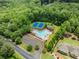 Overhead view of a community pool and tennis courts nestled in a wooded area at 7820 Longview Dr, Cumming, GA 30041