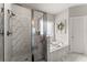 Bright bathroom featuring a glass-enclosed shower and separate soaking tub with decorative wreath at 7820 Longview Dr, Cumming, GA 30041