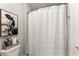 Bathroom featuring a toilet, shower with striped curtain, and country-style cow themed artwork at 7820 Longview Dr, Cumming, GA 30041