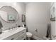 Well-lit half bathroom boasts a round mirror, modern vanity, and charming barn-themed artwork at 7820 Longview Dr, Cumming, GA 30041