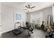 Bedroom featuring a ceiling fan, window and gym equipment, including a treadmill and rowing machine at 7820 Longview Dr, Cumming, GA 30041