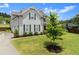 Well-maintained home with a two-car garage, lush lawn, and a young tree in a landscaped yard at 7820 Longview Dr, Cumming, GA 30041