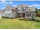 A stunning two-story home with a brick and siding facade, showcasing its beautifully maintained front yard at 7820 Longview Dr, Cumming, GA 30041