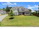 Inviting two-story home with well-manicured lawn, featuring gray siding and complemented by lush landscaping at 7820 Longview Dr, Cumming, GA 30041