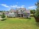 Eye-catching two-story home featuring lush green lawn with mature tree, with a gray exterior, and brick accents at 7820 Longview Dr, Cumming, GA 30041
