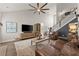Well-lit living room featuring a ceiling fan, hardwood floors, and leather furniture at 7820 Longview Dr, Cumming, GA 30041