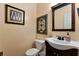 Powder room includes decorative mirror, single sink vanity and low-flow toilet at 2621 Garland Way, Duluth, GA 30096