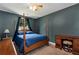 Bedroom with four-poster bed, dark blue walls, and a window with natural light at 2621 Garland Way, Duluth, GA 30096