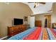 Well lit main bedroom featuring two dressers, vaulted ceiling, fan and TV at 2621 Garland Way, Duluth, GA 30096
