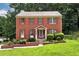 Charming brick home featuring red shutters, a well-manicured lawn and beautiful landscaping at 2621 Garland Way, Duluth, GA 30096