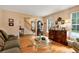 Bright living room features hardwood floors, comfortable seating and direct access to staircase at 2621 Garland Way, Duluth, GA 30096