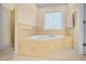 Well lit bathroom with a jacuzzi tub, tile surround, and glass door shower at 3460 Drayton Manor Run, Lawrenceville, GA 30046