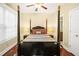 Cozy bedroom featuring hardwood floors and a four-poster bed and a view to the en-suite at 3460 Drayton Manor Run, Lawrenceville, GA 30046