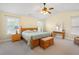 Bright bedroom featuring a wooden bed, large windows, and a ceiling fan, providing ample natural light and ventilation at 3460 Drayton Manor Run, Lawrenceville, GA 30046