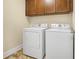 Laundry room featuring a tile floor, cabinets, a washer and a dryer at 3460 Drayton Manor Run, Lawrenceville, GA 30046