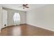 This bedroom features hardwood floors, neutral walls, a ceiling fan, a window, and an interior door at 4282 Roswell Ne Rd # K3, Atlanta, GA 30342