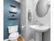 Charming half bathroom with floating shelves, toilet, and stylish pedestal sink at 884 Edgewater Cir, Marietta, GA 30062