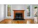 Cozy fireplace with wood mantle is flanked by windows providing ample natural light and hardwood floors at 884 Edgewater Cir, Marietta, GA 30062