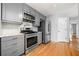 Modern kitchen featuring stainless steel appliances, gray cabinetry, granite countertops, and hardwood floors at 884 Edgewater Cir, Marietta, GA 30062