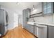 Well-equipped kitchen featuring gray cabinets, stainless steel appliances, a farmhouse sink, and hardwood floors at 884 Edgewater Cir, Marietta, GA 30062