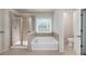 Bright primary bathroom features a glass shower, soaking tub with tile surround, and open-door access to a water closet at 1120 Bagwell Dr, Kennesaw, GA 30152