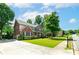 Charming brick home featuring a well-manicured front lawn, lush greenery, and a paved driveway at 1120 Bagwell Dr, Kennesaw, GA 30152