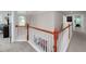 An upstairs hallway features hardwood railing, neutral carpet, and views of a dining room through the railing at 1120 Bagwell Dr, Kennesaw, GA 30152