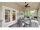 Covered porch with a dining table, ceiling fan, and view of a lush backyard at 1120 Bagwell Dr, Kennesaw, GA 30152