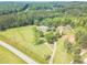 Aerial view of a home with a barn on a expansive lot lined with mature trees and grassy fields at 2229 S Van Wert S Rd, Villa Rica, GA 30180