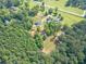 Aerial view of a home nestled in a wooded area with a long driveway and green lawn at 2229 S Van Wert S Rd, Villa Rica, GA 30180