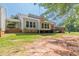 Rear exterior featuring a covered porch, back windows, and mature trees with grassy yard at 2229 S Van Wert S Rd, Villa Rica, GA 30180