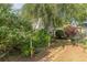 Beautifully landscaped backyard with mature trees, lush greenery, and a stone pathway at 2229 S Van Wert S Rd, Villa Rica, GA 30180