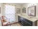 Bathroom boasts vanity with marble countertop, decorative mirror, and chair with patterned cushion at 2229 S Van Wert S Rd, Villa Rica, GA 30180