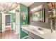 Hallway of bathrooms, gray vanity, green walls, and wood floors at 2229 S Van Wert S Rd, Villa Rica, GA 30180
