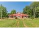 Charming red barn home with a covered porch and lush green lawn, offering a peaceful retreat at 2229 S Van Wert S Rd, Villa Rica, GA 30180