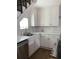 A kitchen with white cabinets, stainless steel appliances, and decorative backsplash beneath stairs at 2229 S Van Wert S Rd, Villa Rica, GA 30180