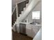 Bright kitchen with white cabinets, stainless steel appliances, and decorative backsplash beneath stairs at 2229 S Van Wert S Rd, Villa Rica, GA 30180