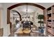 Open-concept dining room with an arched entrance, dark wood floors, and a stylish light fixture at 2837 Peachstone Ct, Lawrenceville, GA 30043