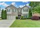 Charming two-story home features a well-manicured lawn, lush landscaping, and a welcoming two-car garage at 2837 Peachstone Ct, Lawrenceville, GA 30043