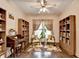 Inviting home office boasts custom bookshelves, wood floors, a ceiling fan, and ample natural light at 2837 Peachstone Ct, Lawrenceville, GA 30043