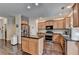 Well-lit kitchen features wood cabinets, stainless steel appliances, black countertops and dark wood floors at 2837 Peachstone Ct, Lawrenceville, GA 30043