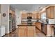 Well-lit kitchen features wood cabinets, stainless steel appliances, black countertops and dark wood floors at 2837 Peachstone Ct, Lawrenceville, GA 30043