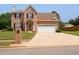 Traditional two story brick home with a two car garage, manicured lawn, and mature trees at 2928 Riverset Ct, Decatur, GA 30034