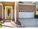Close-up view of a two-car garage and covered front entrance with brick and stone accents at 2928 Riverset Ct, Decatur, GA 30034